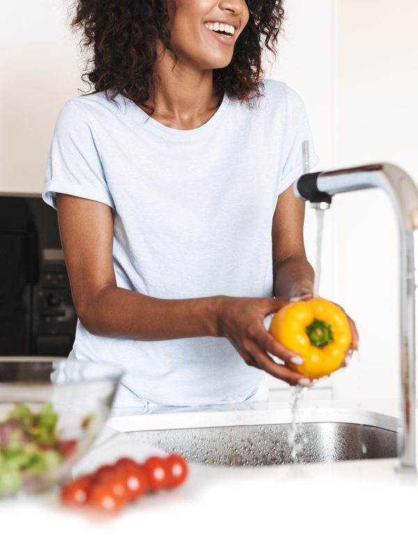 Woman washing vegetables with clean water